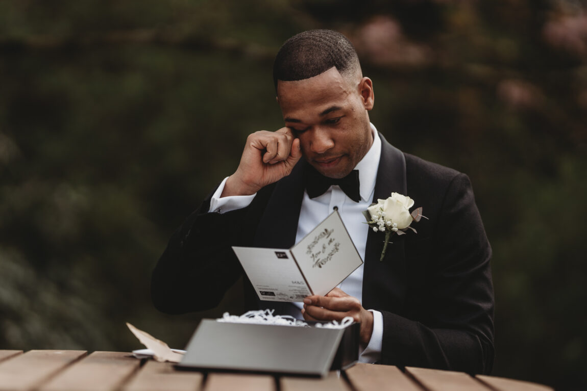 Groom wiping away a tear as he reads a letter from the bride, documentary wedding photography by Matt Wing