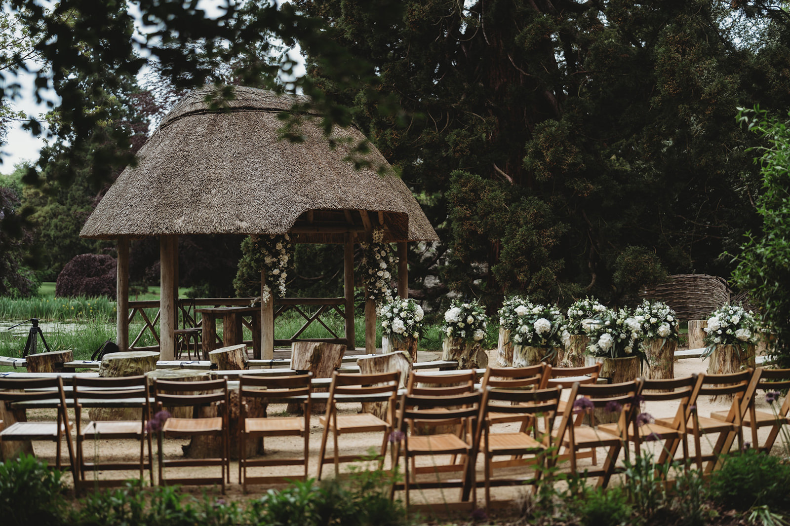 Wooden chairs set out under the thatched Lapa at The Orangery Maidstone