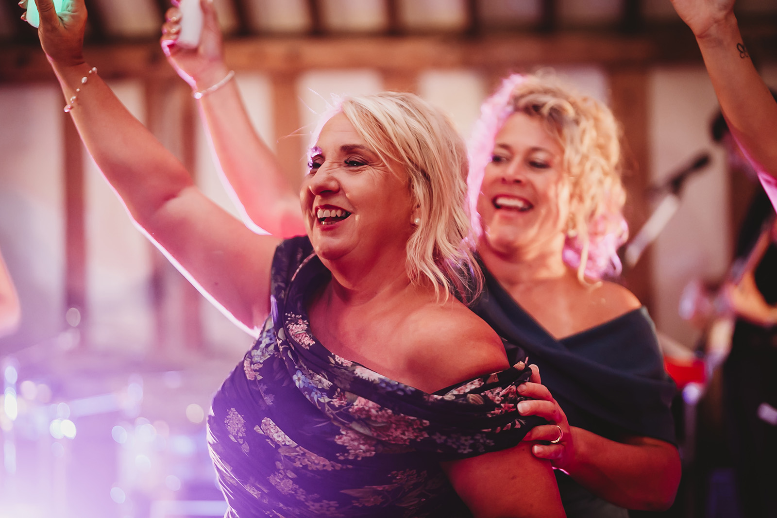 Guests dancing with arms in the air late in the evening, documentary wedding photography