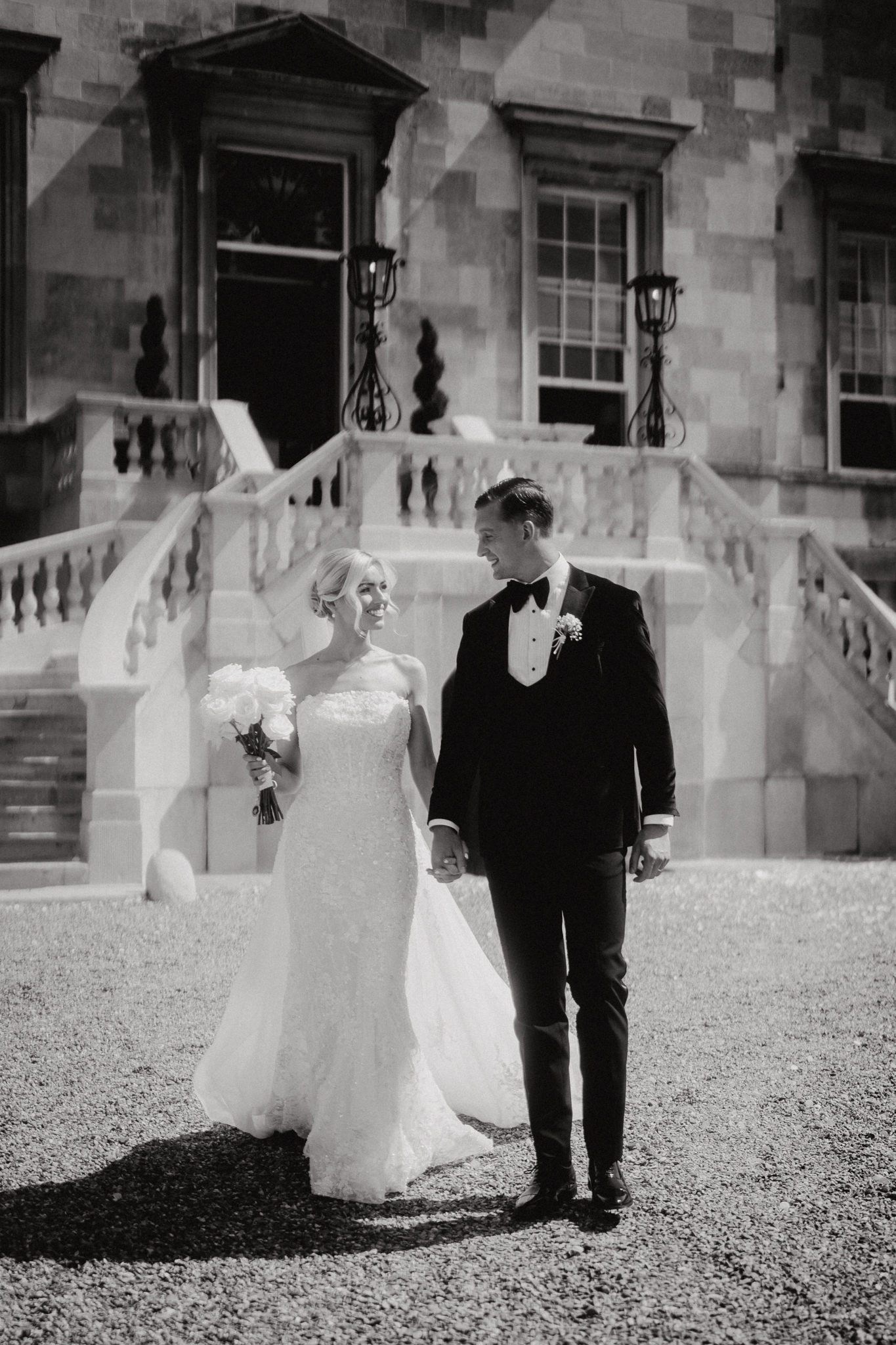Bride and groom on the sweeping stairs of Botleys Mansion, Surrey