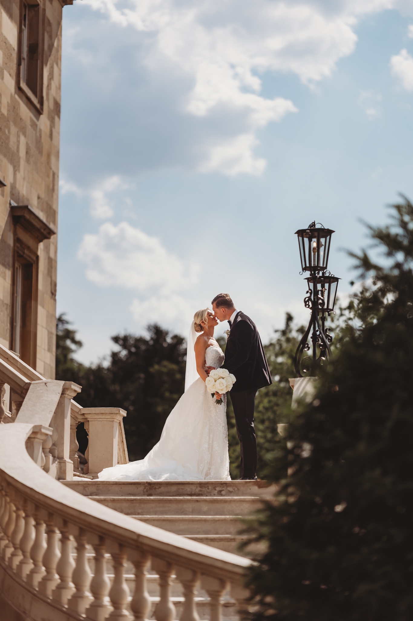 Bride and groom on the sweeping stairs of Botleys Mansion, Surrey