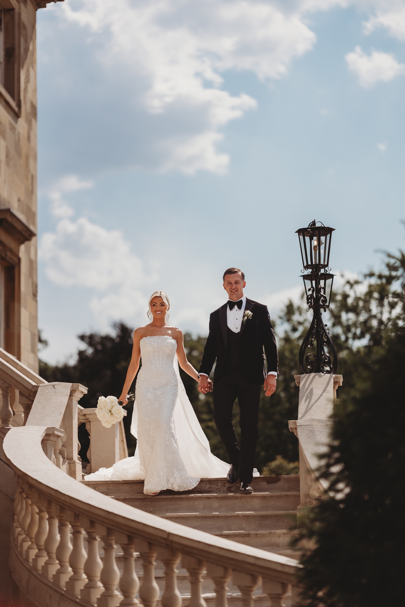 Bride and groom on the sweeping stairs of Botleys Mansion, Surrey