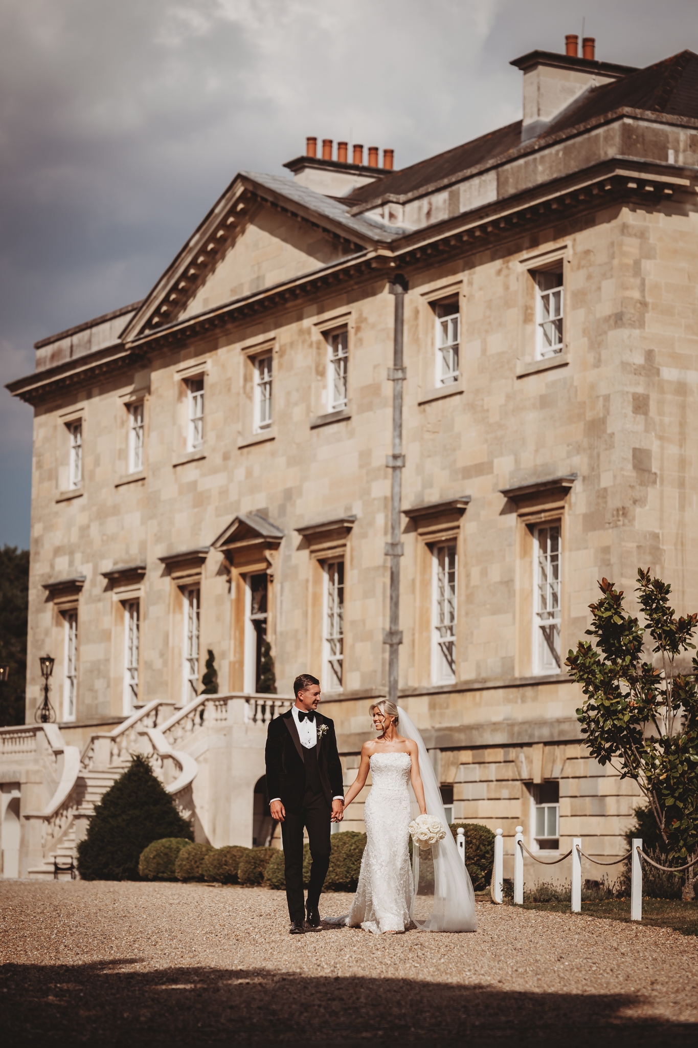 Bride and groom on the sweeping stairs of Botleys Mansion, Surrey