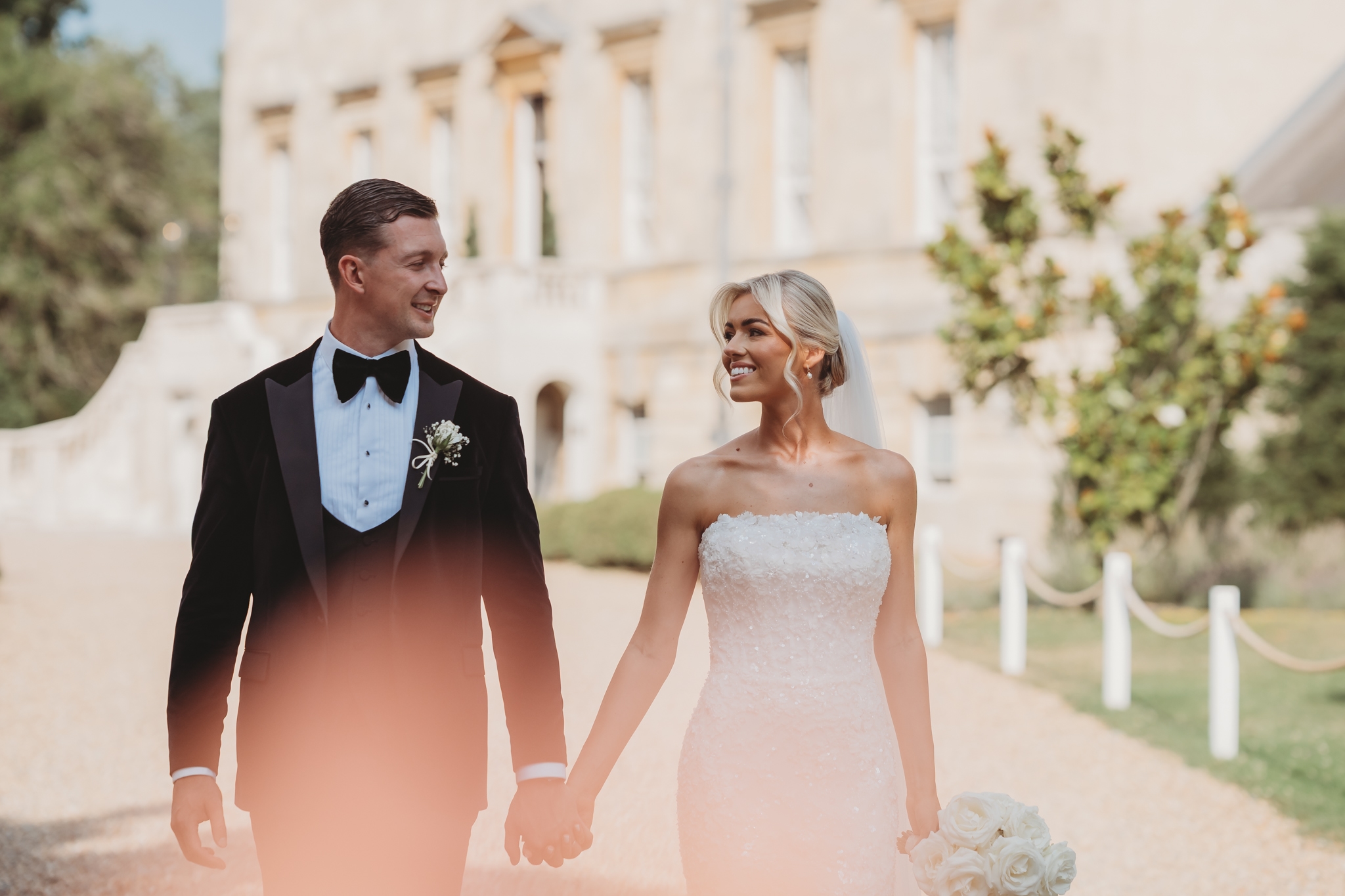 Bride and groom on the sweeping stairs of Botleys Mansion, Surrey