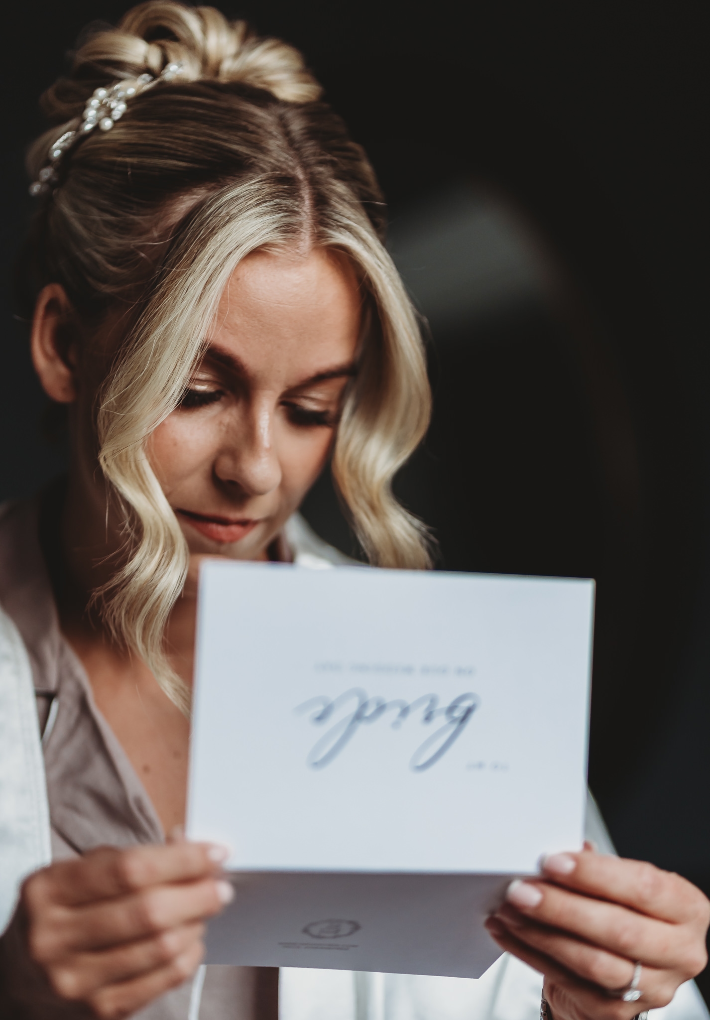 A bride reading a card addressed to her on the wedding morning, candid documentary photograph