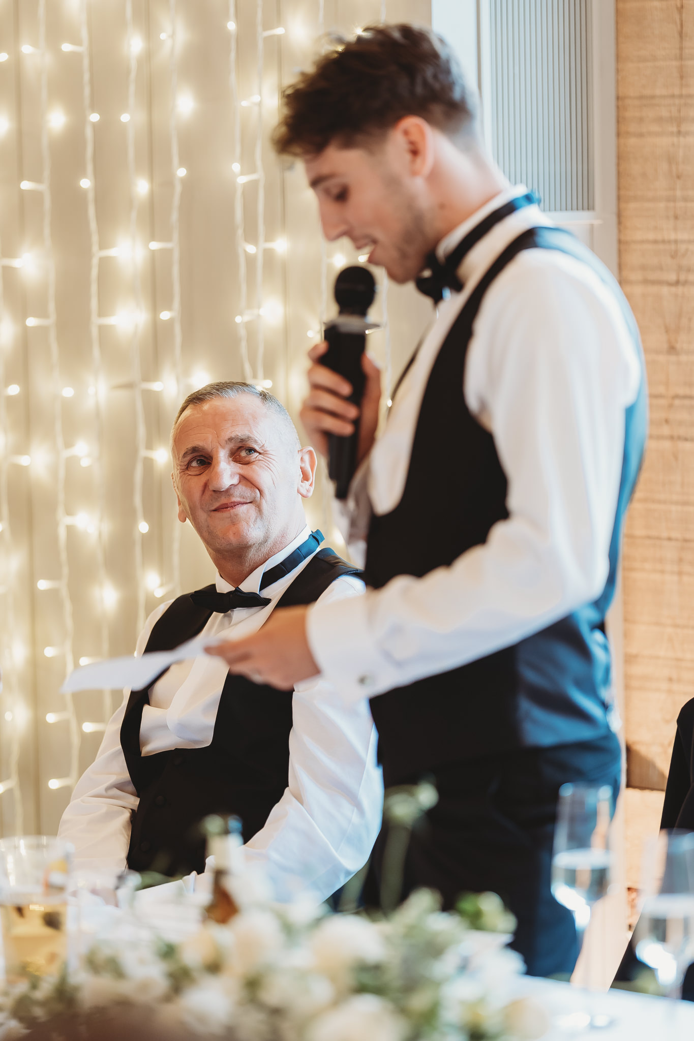 Ella & Ryan / Rackleys Barn 45 Wedding speeches under festoon lights at Rackleys Barn — Buckinghamshire wedding photographer