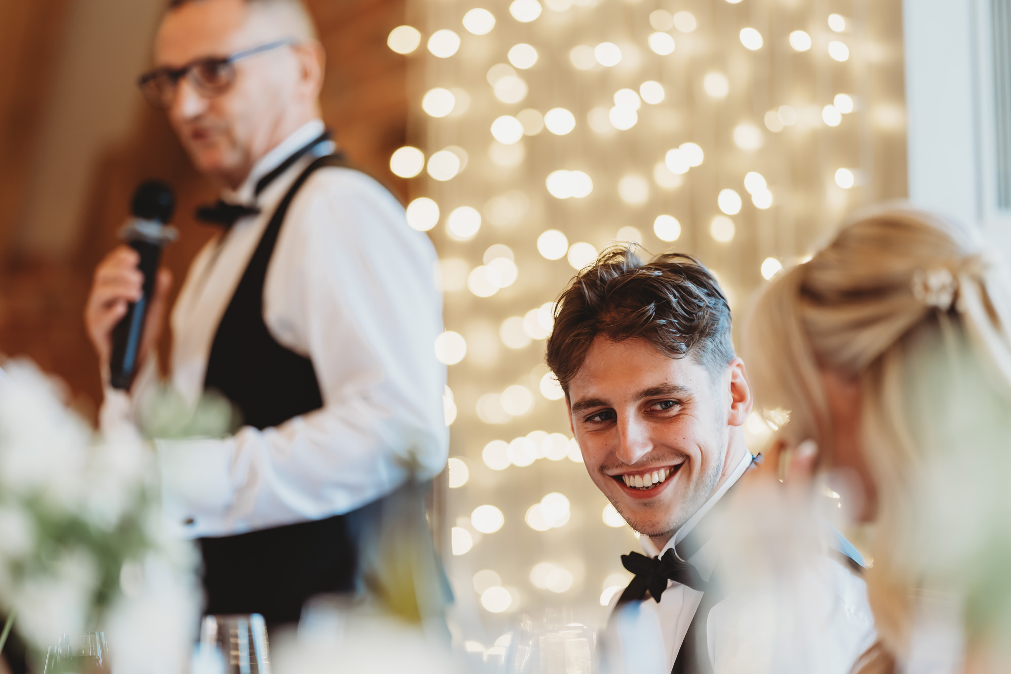 Ella & Ryan / Rackleys Barn 51 Wedding speeches under festoon lights at Rackleys Barn — Buckinghamshire wedding photographer