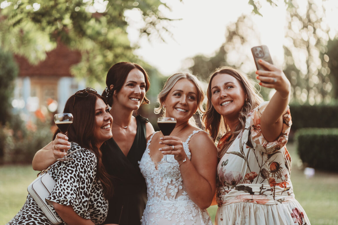 Bride and friends taking a selfie on the lawn