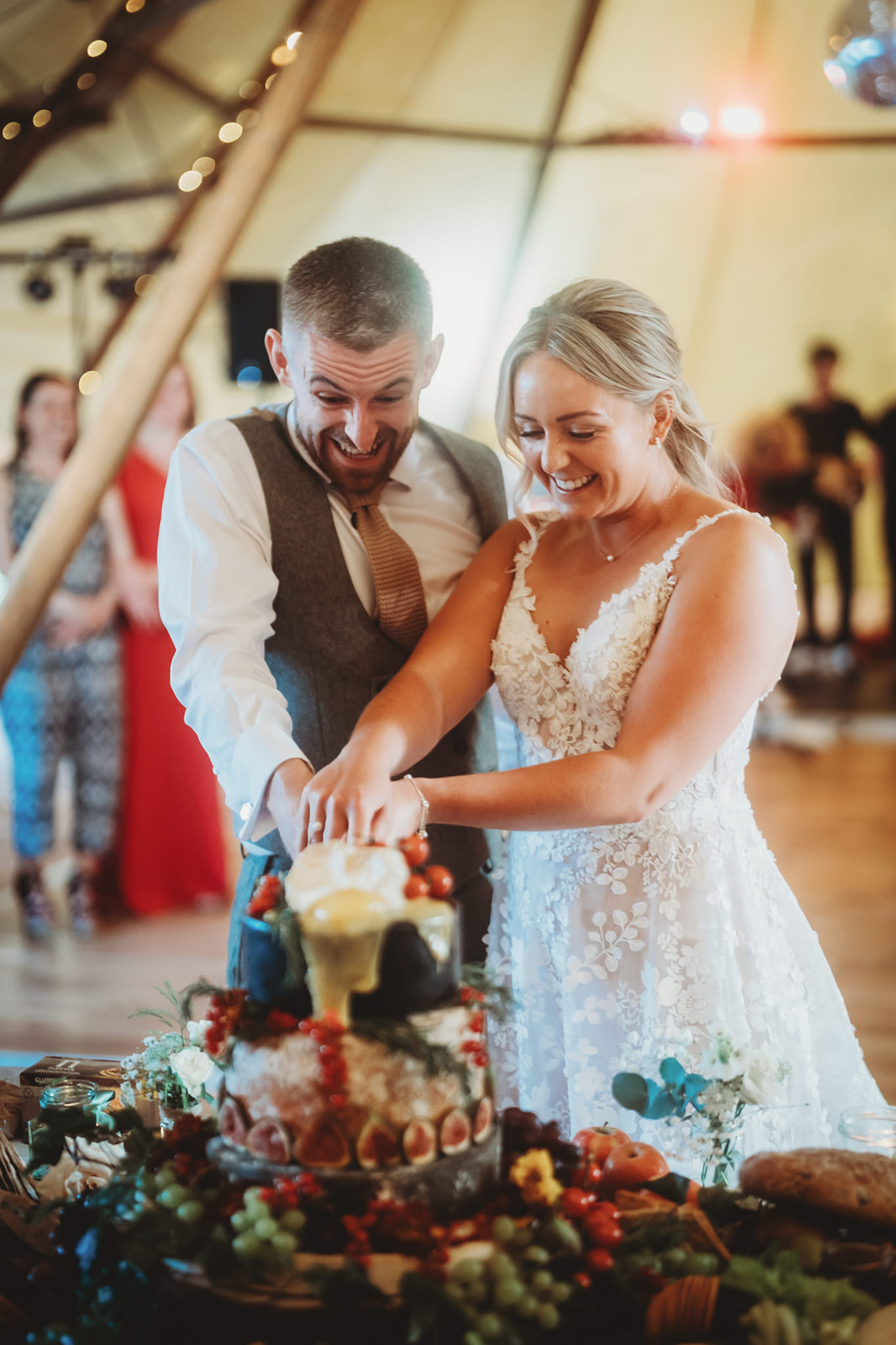 Sarah and Daniel cutting the cake in the tipi