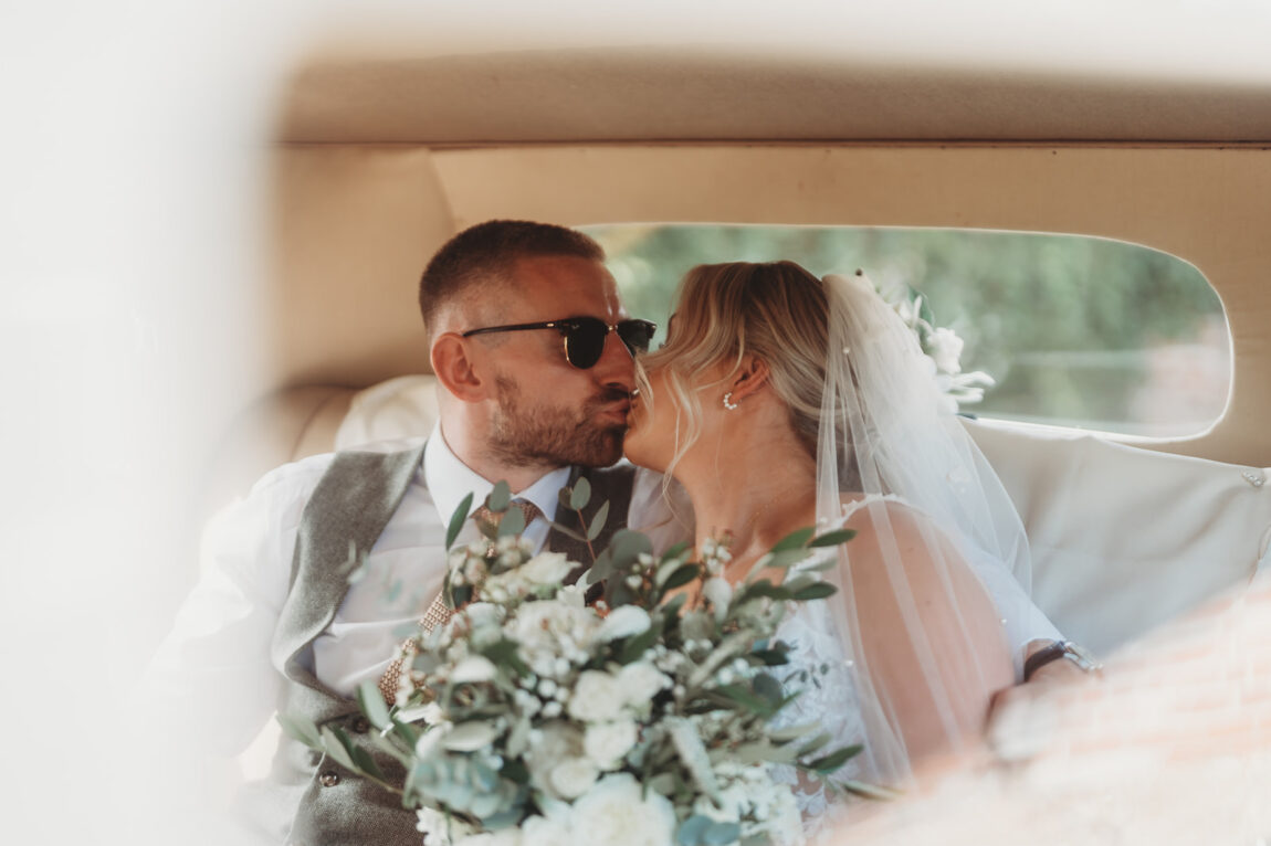 Bride and groom in the back of the wedding car