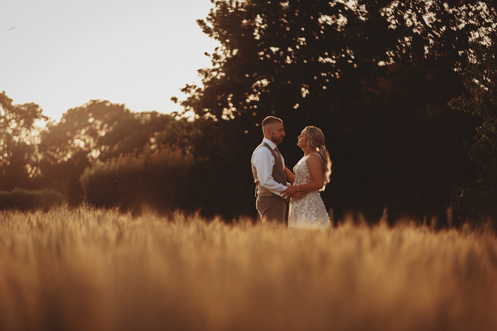 Couple in a field at golden hour near Barnston Lodge