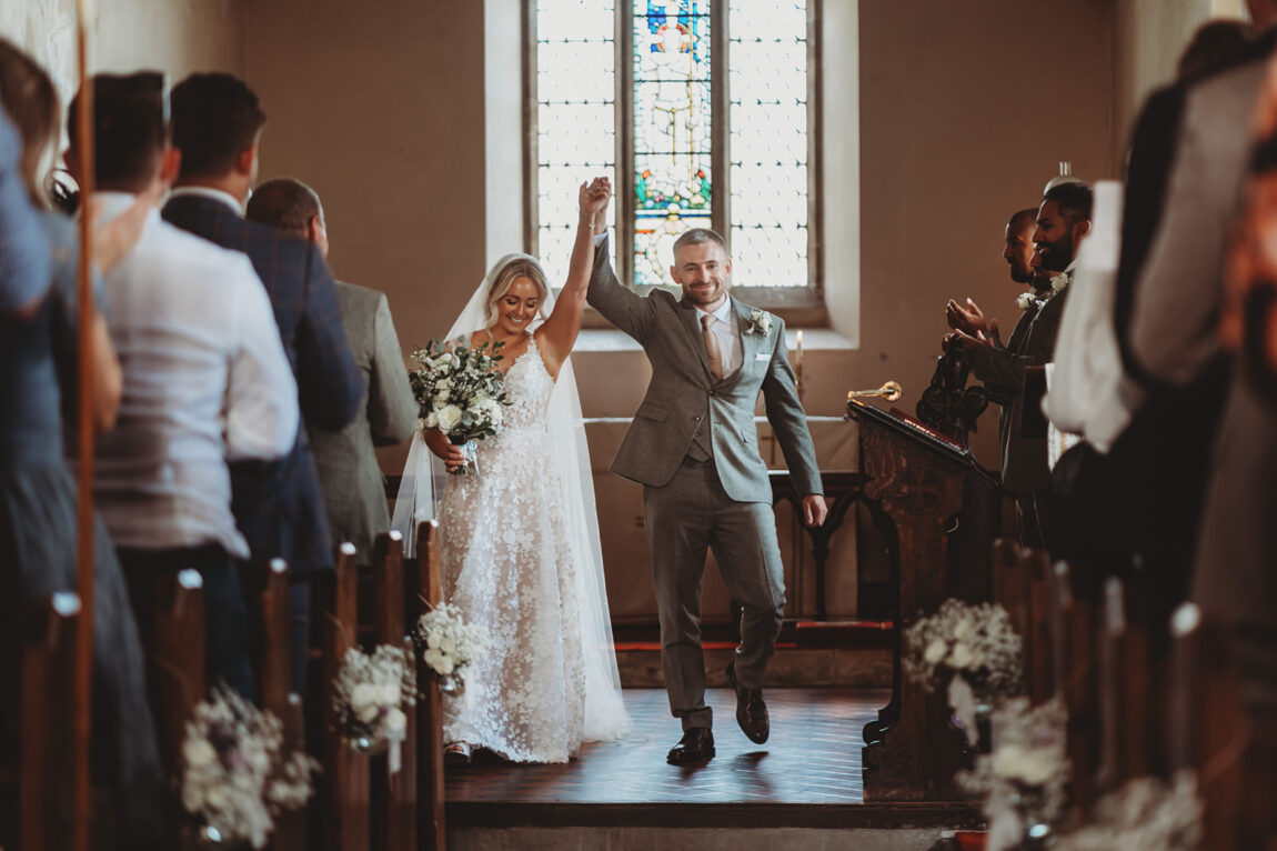 Bride and groom celebrating as they walk back down the aisle