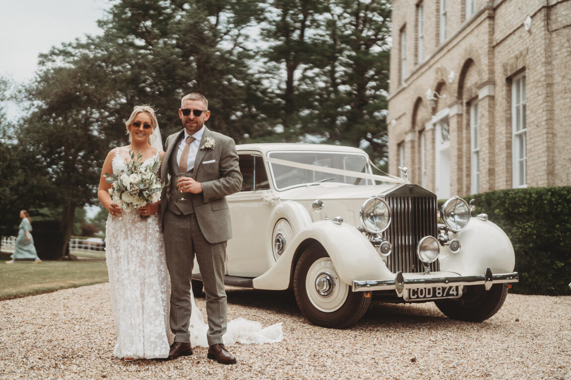 Bride and groom with the vintage Rolls-Royce in front of Barnston Lodge