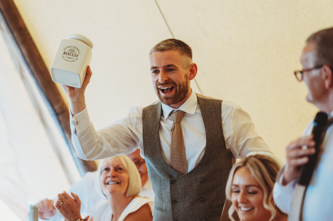 Groom laughing during the speeches in the tipi at Barnston Lodge