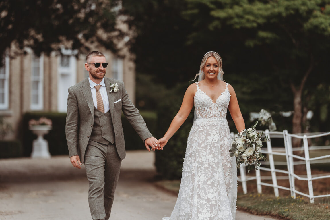 Sarah and Daniel walking across the grounds of Barnston Lodge