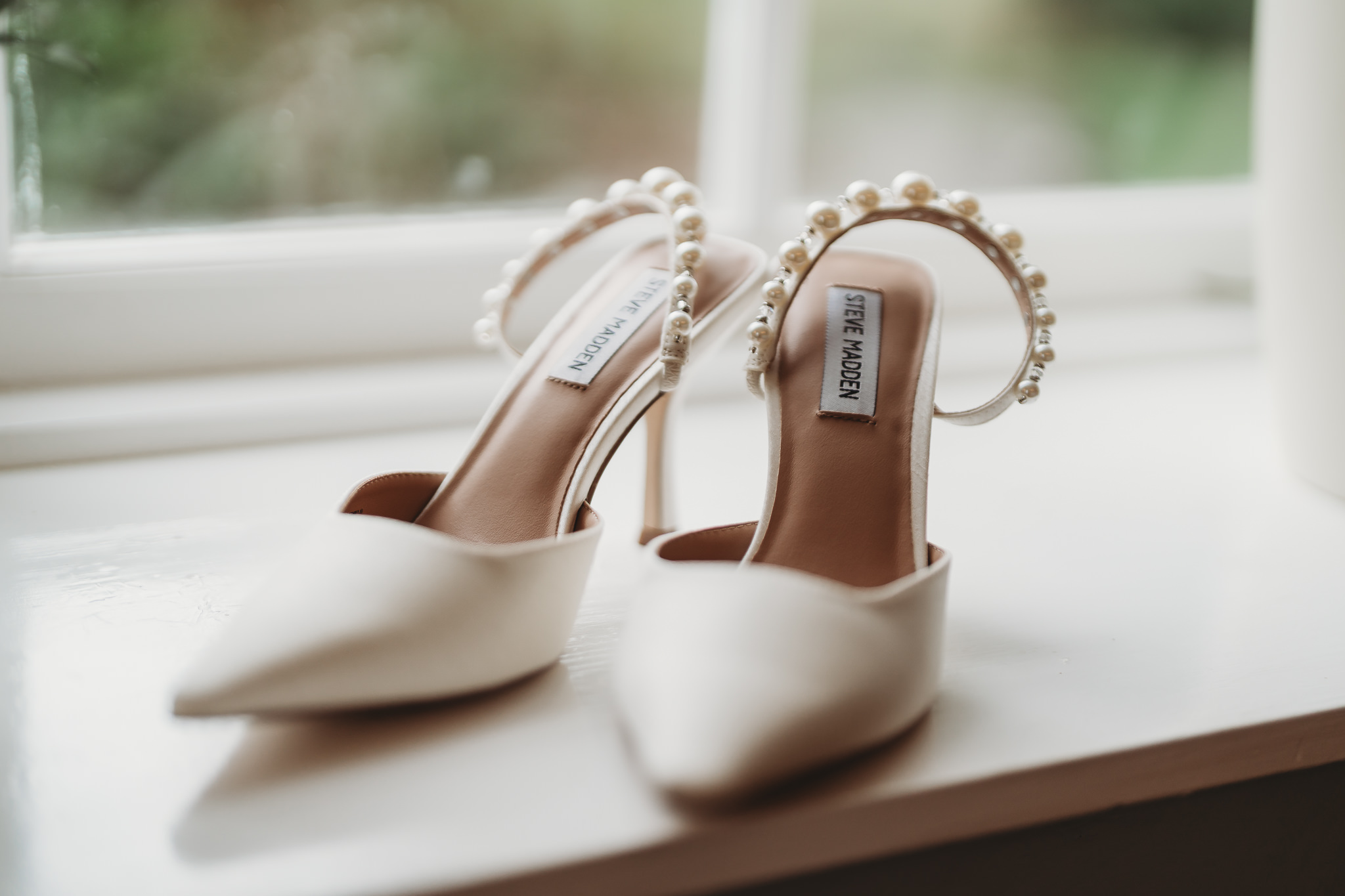 Laura & Liam / The Green Cornwall 4 Pearl-strapped bridal shoes on a windowsill at The Green Cornwall
