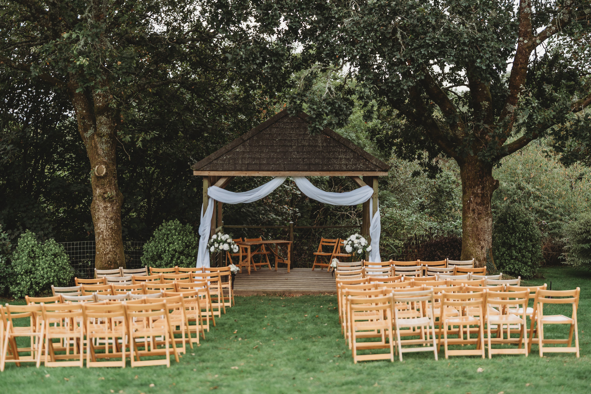 The oak arbour set for an outdoor ceremony at The Green Cornwall, overlooking the valley