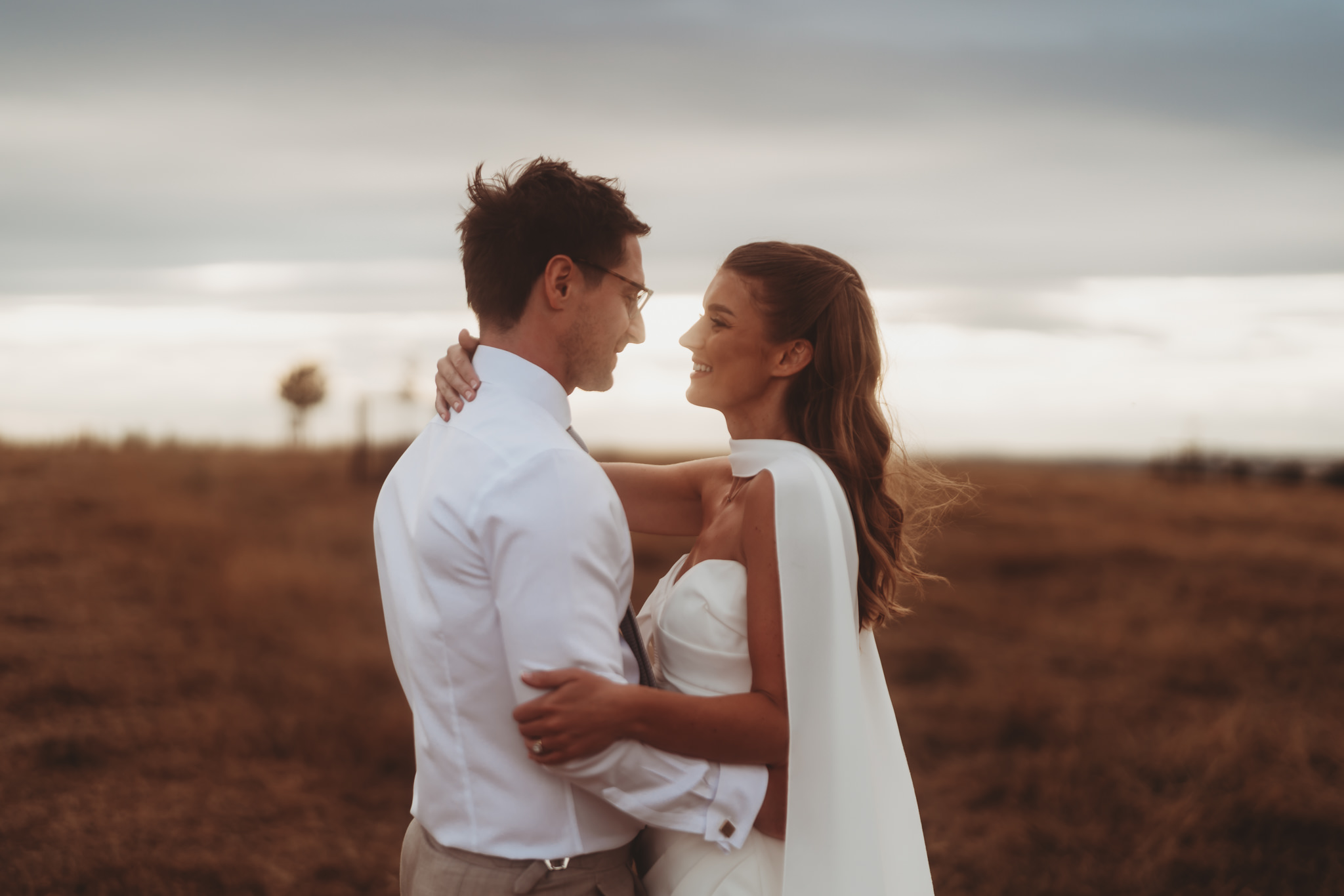 Hartland Abbey wedding photographer Matt Wing, a photo from another wedding: bride and groom holding each other under a big sky
