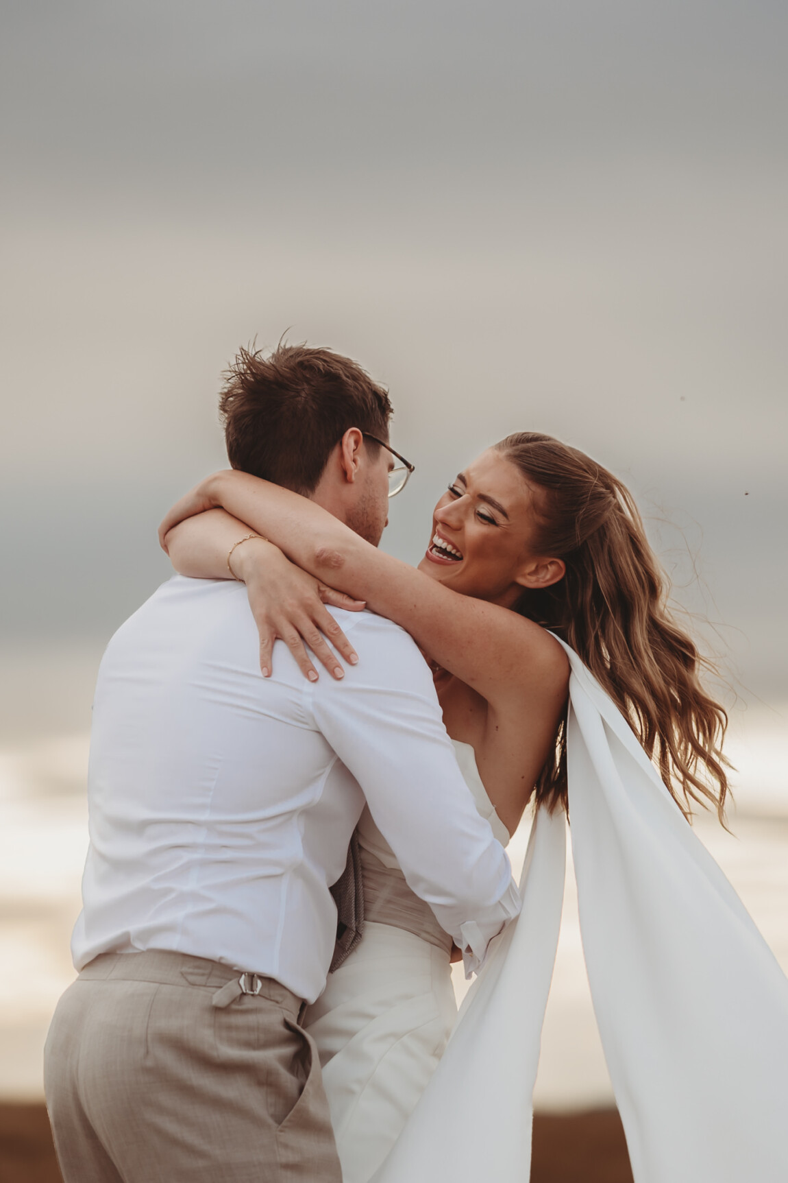 documentary wedding photography — Louise and George laughing in a hug at Primrose Hill Farm