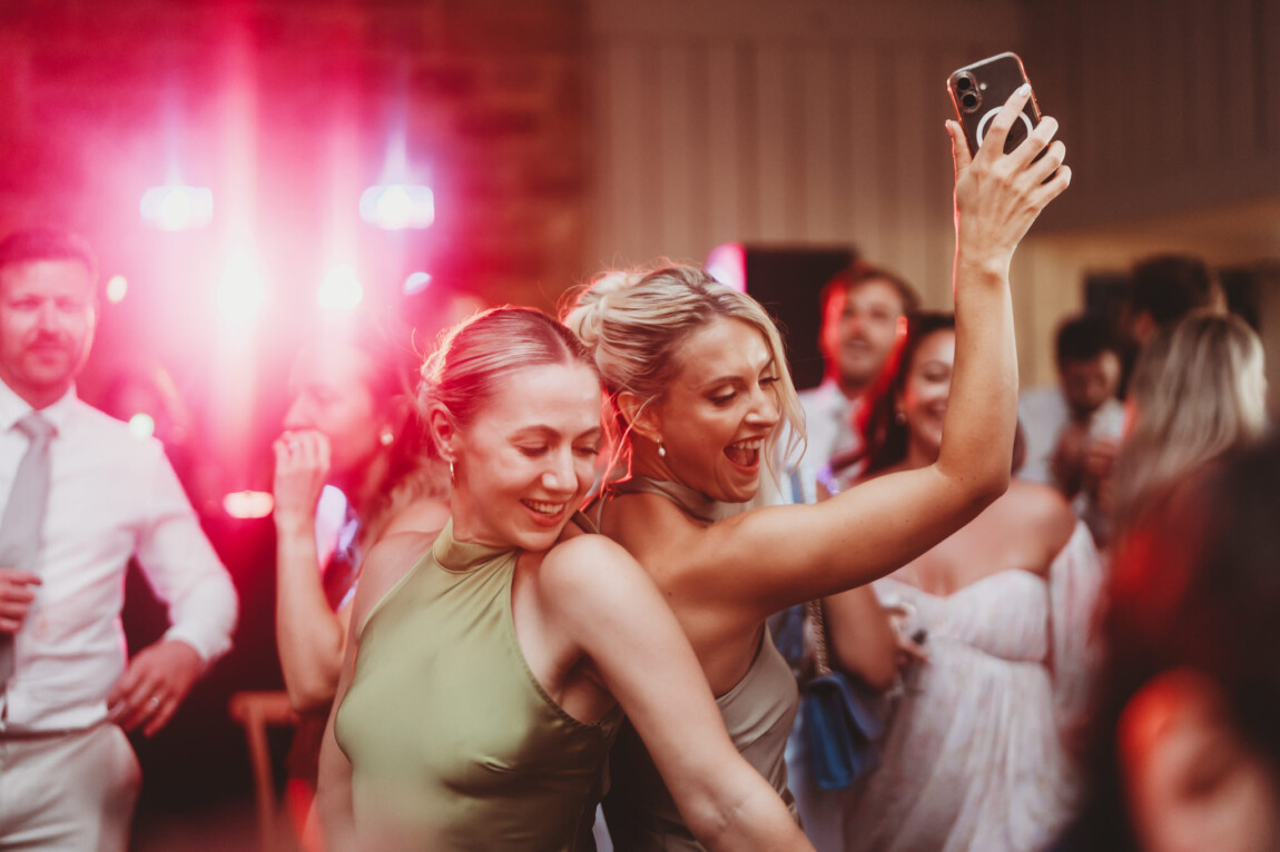 Guests dancing under coloured lights, documentary wedding photography by Matt Wing