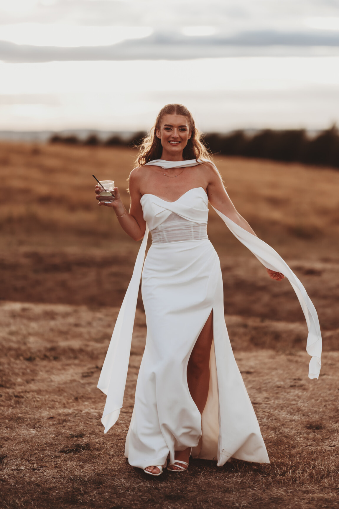 Bride with her cape blowing in the wind, documentary wedding photography by Matt Wing