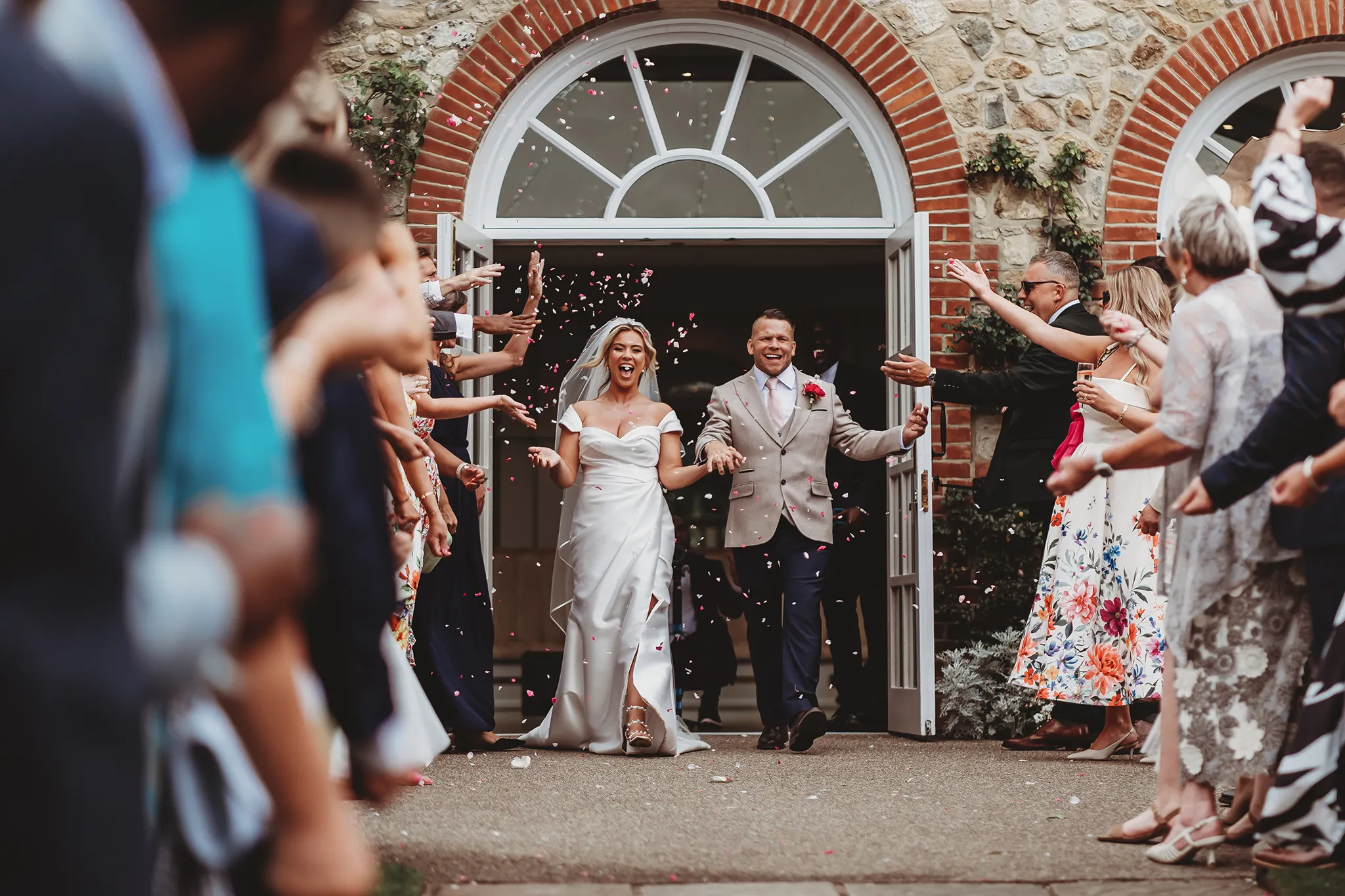 Emily & Alan / The Orangery 23 Confetti through the brick archway at The Orangery Maidstone