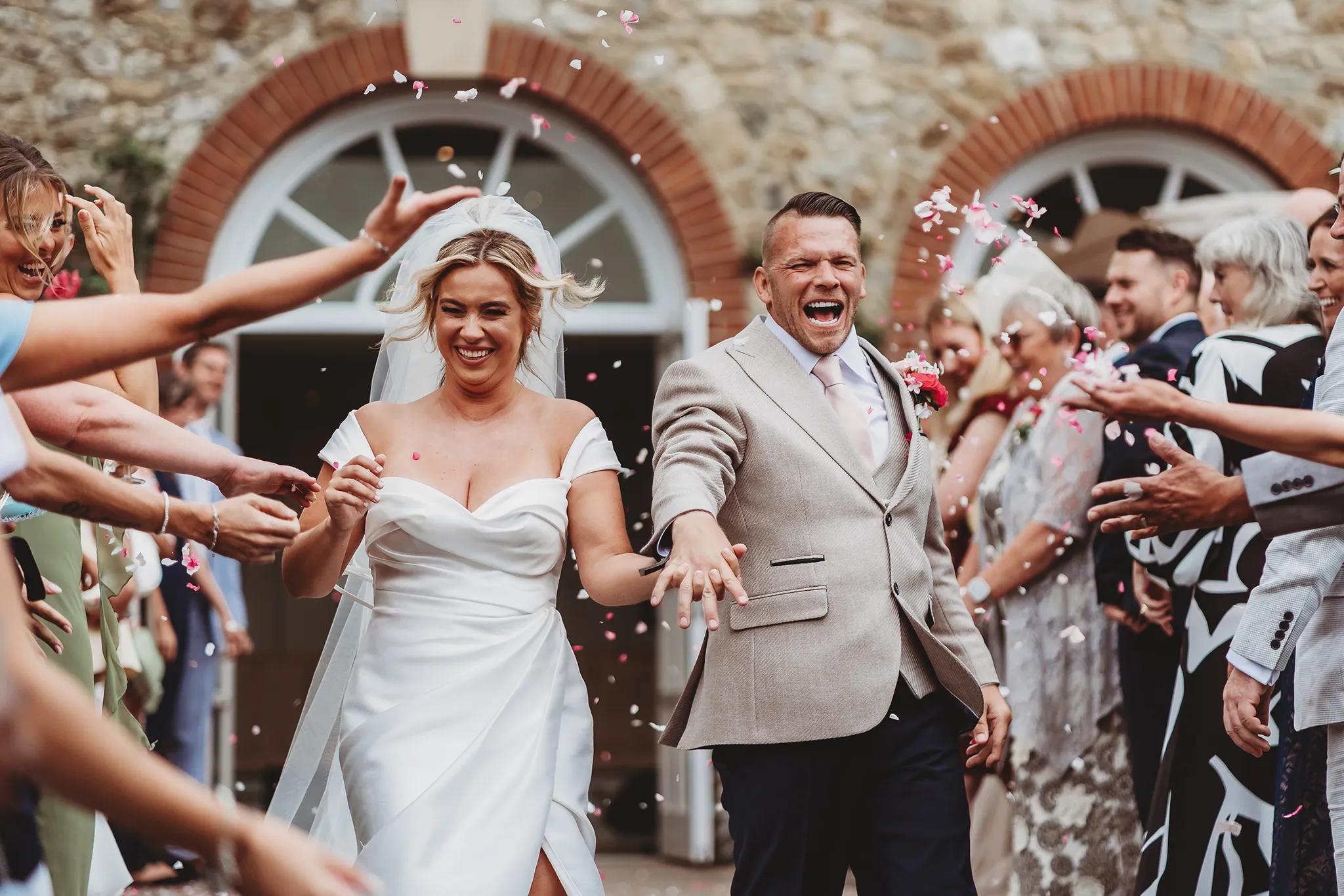 Emily & Alan / The Orangery 25 Alan celebrating through the confetti tunnel
