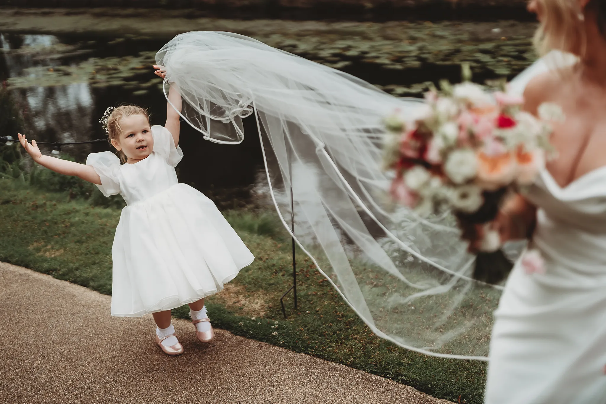 Emily & Alan / The Orangery 28 Emily’s veil caught in the breeze by the water — Orangery Maidstone wedding photography