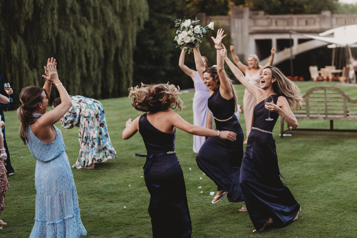 Guests jumping for joy after the bouquet catch at Le Talbooth