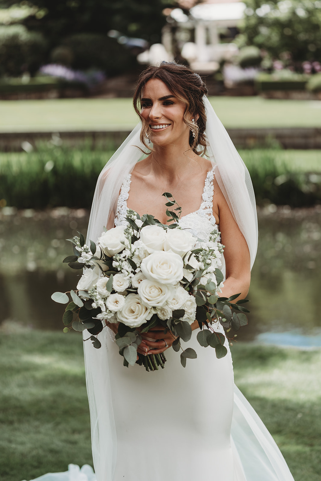 Bride with her bouquet by the River Stour at Le Talbooth