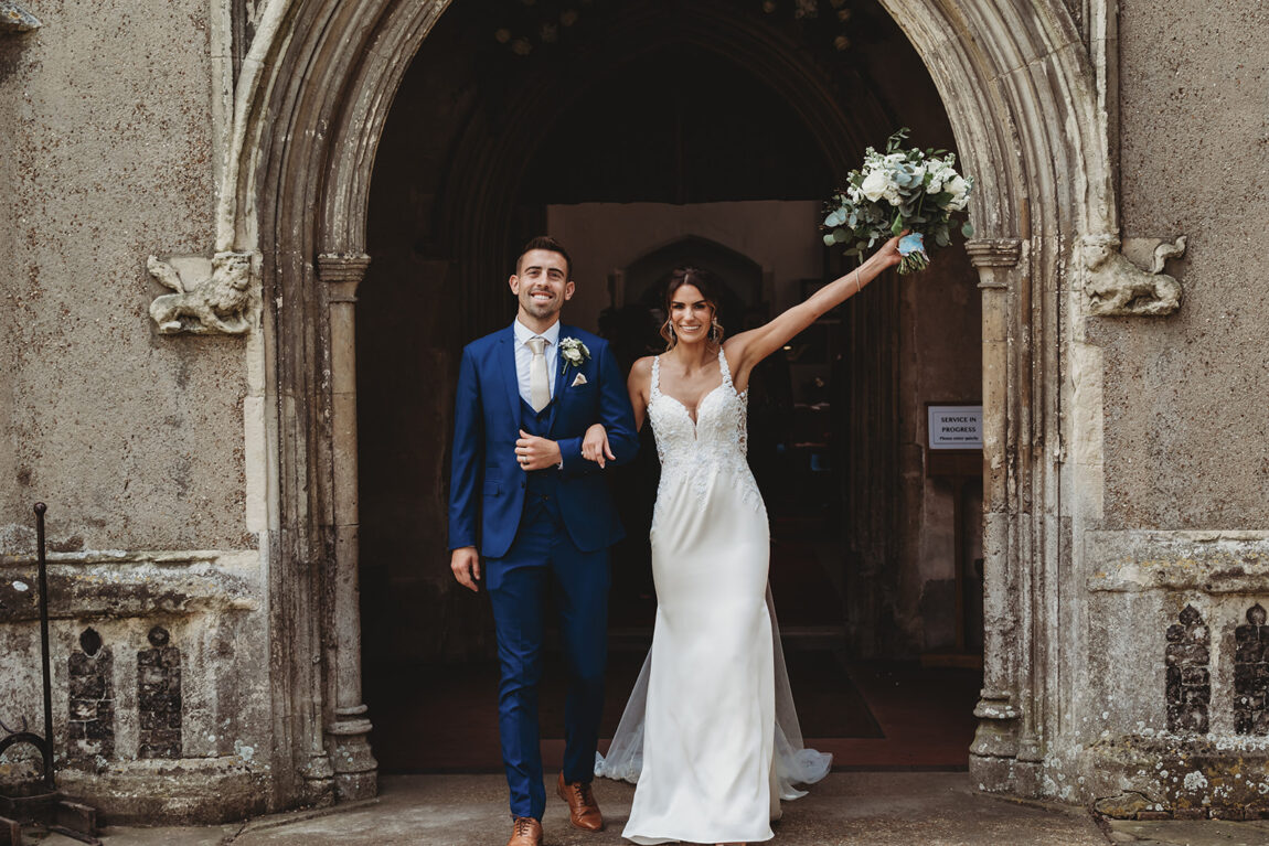 Bride and groom leaving the church, the bride punching the air