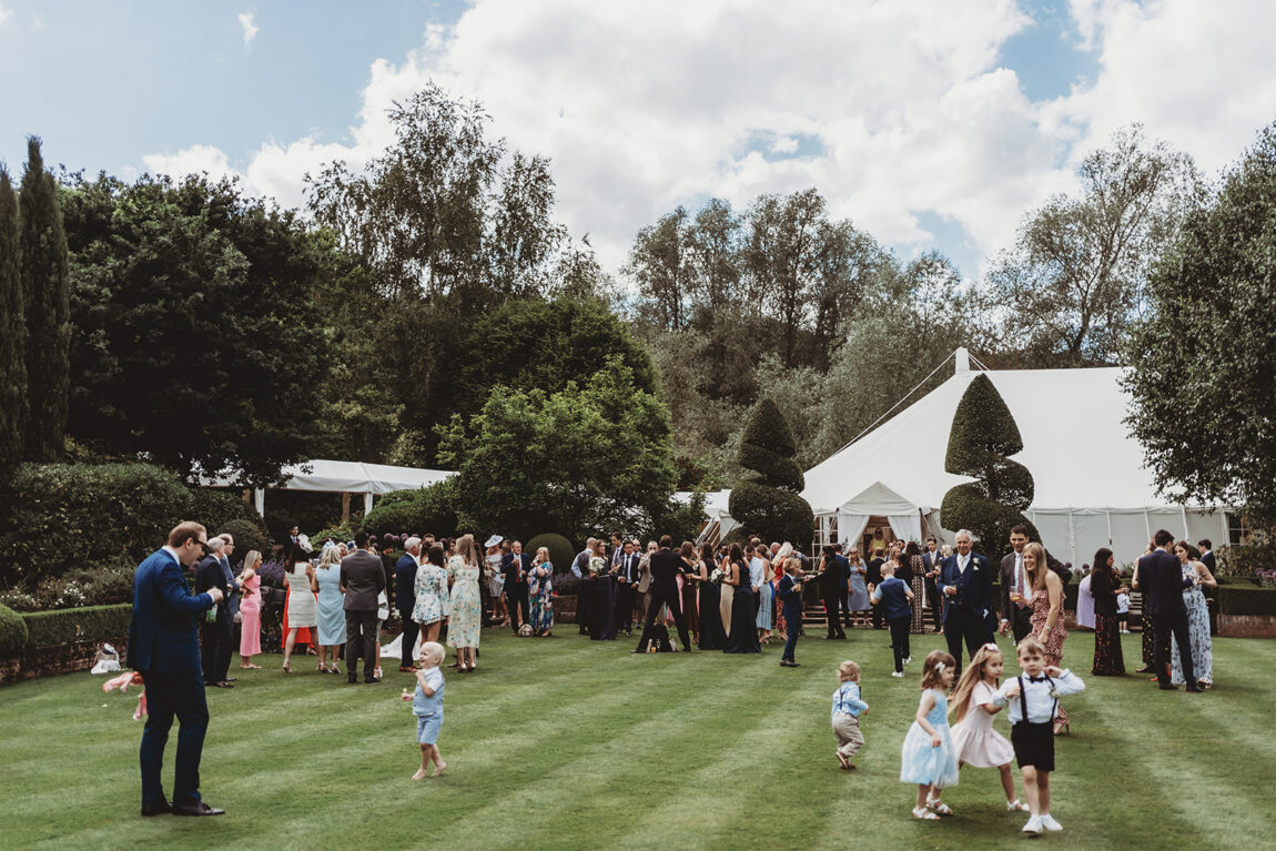 Wedding guests on the lawn in front of the marquee at Le Talbooth