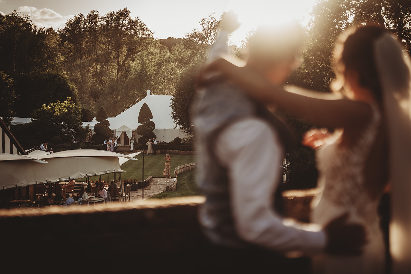 Evening light over the marquee and gardens at Le Talbooth, the couple in the foreground