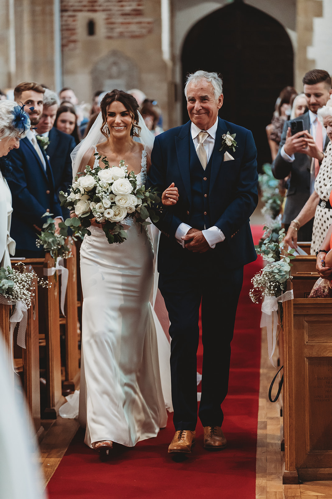 Bride and her father walking down the aisle, smiling