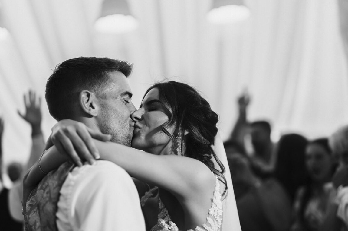 Black and white first dance kiss in the marquee at Le Talbooth