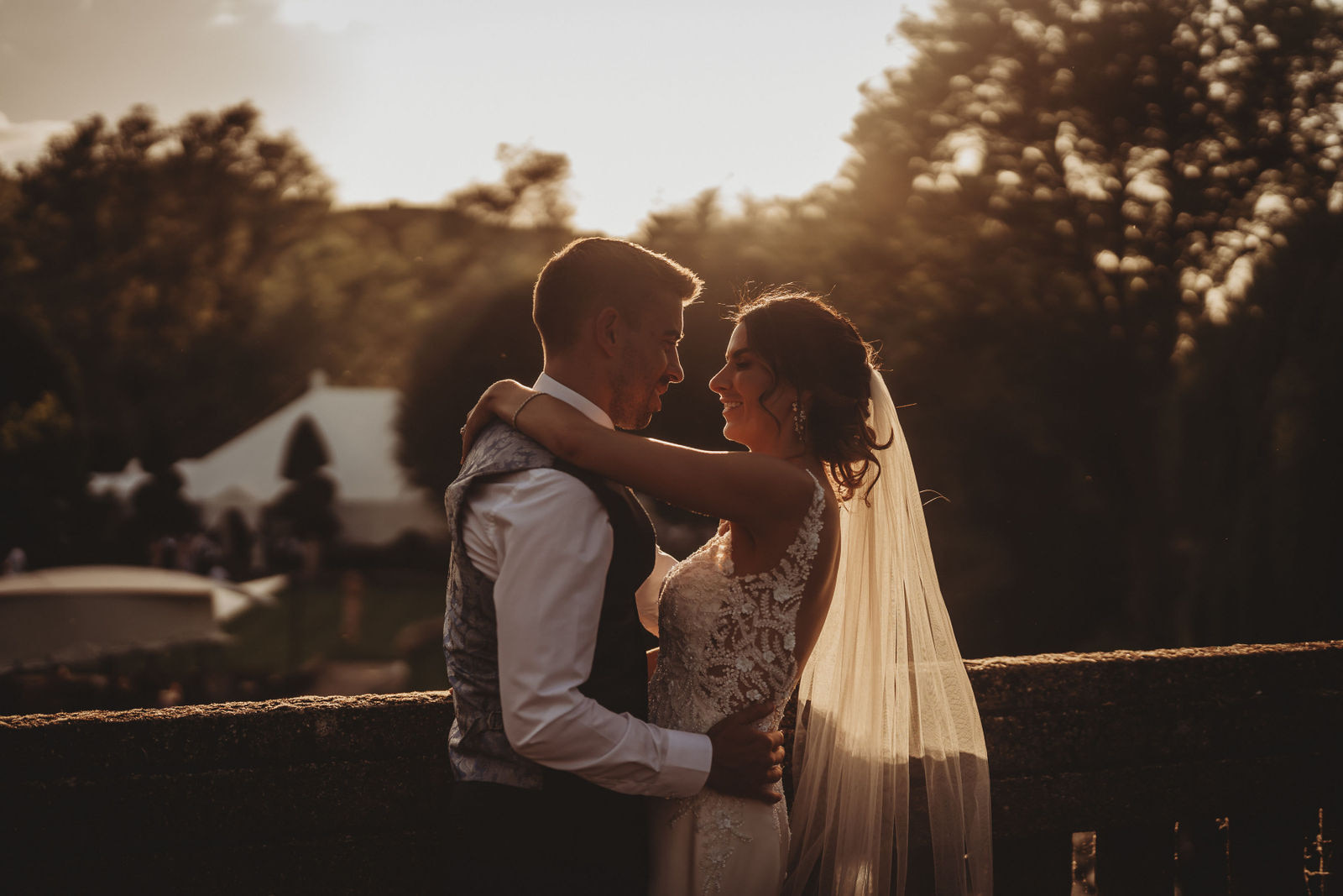 Bride and groom embracing at sunset by the River Stour at Le Talbooth, Dedham, by Le Talbooth wedding photographer Matt Wing