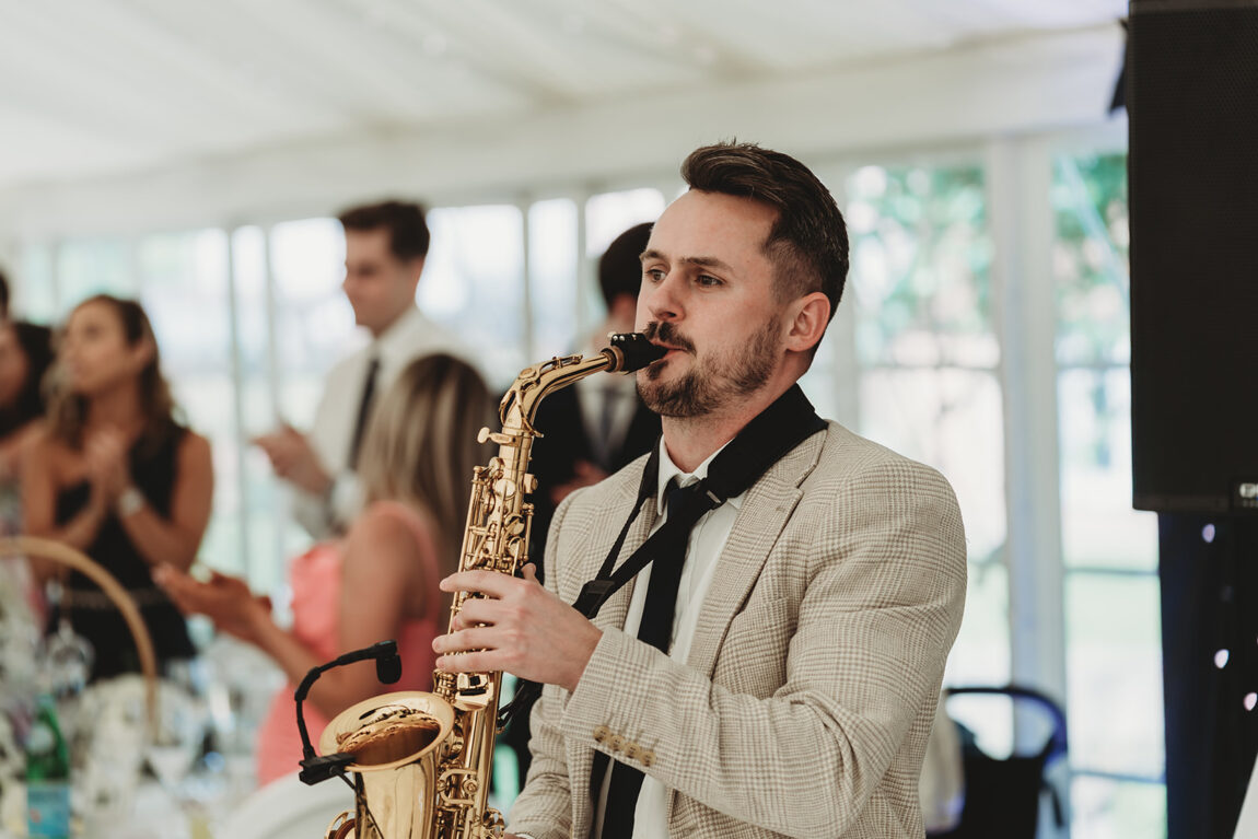 Saxophonist playing to guests in the marquee at Le Talbooth