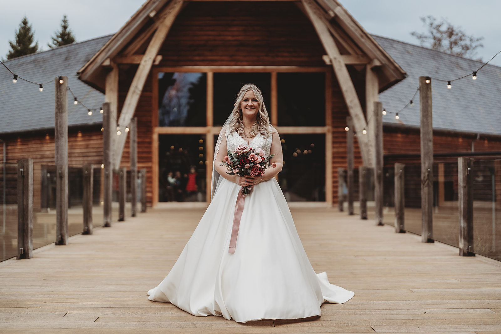 Bride on the walkway in front of the barn at The Mill Barns, Alveley