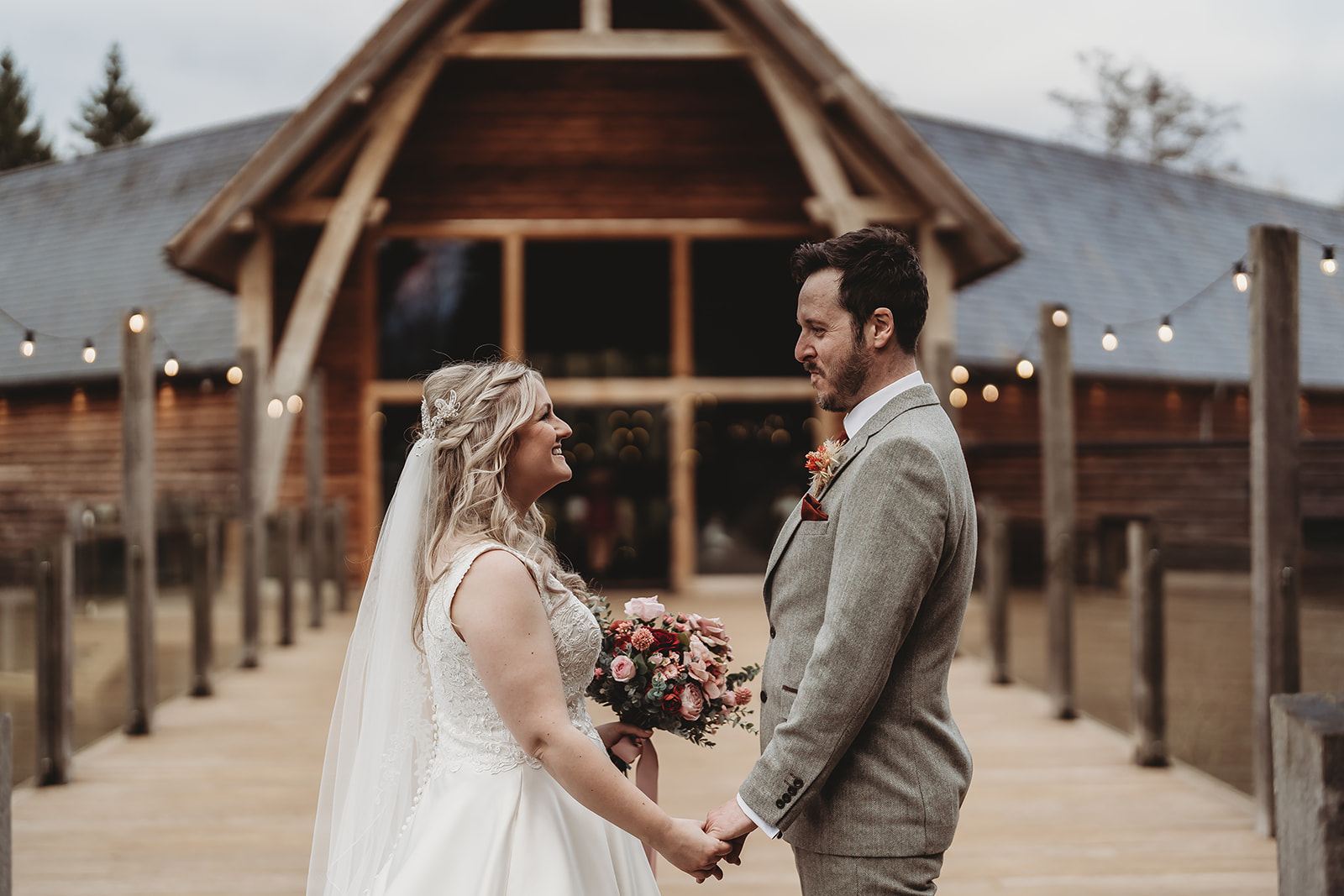 Bride and groom in front of the oak-framed barn at The Mill Barns, Alveley, by Mill Barns wedding photographer Matt Wing