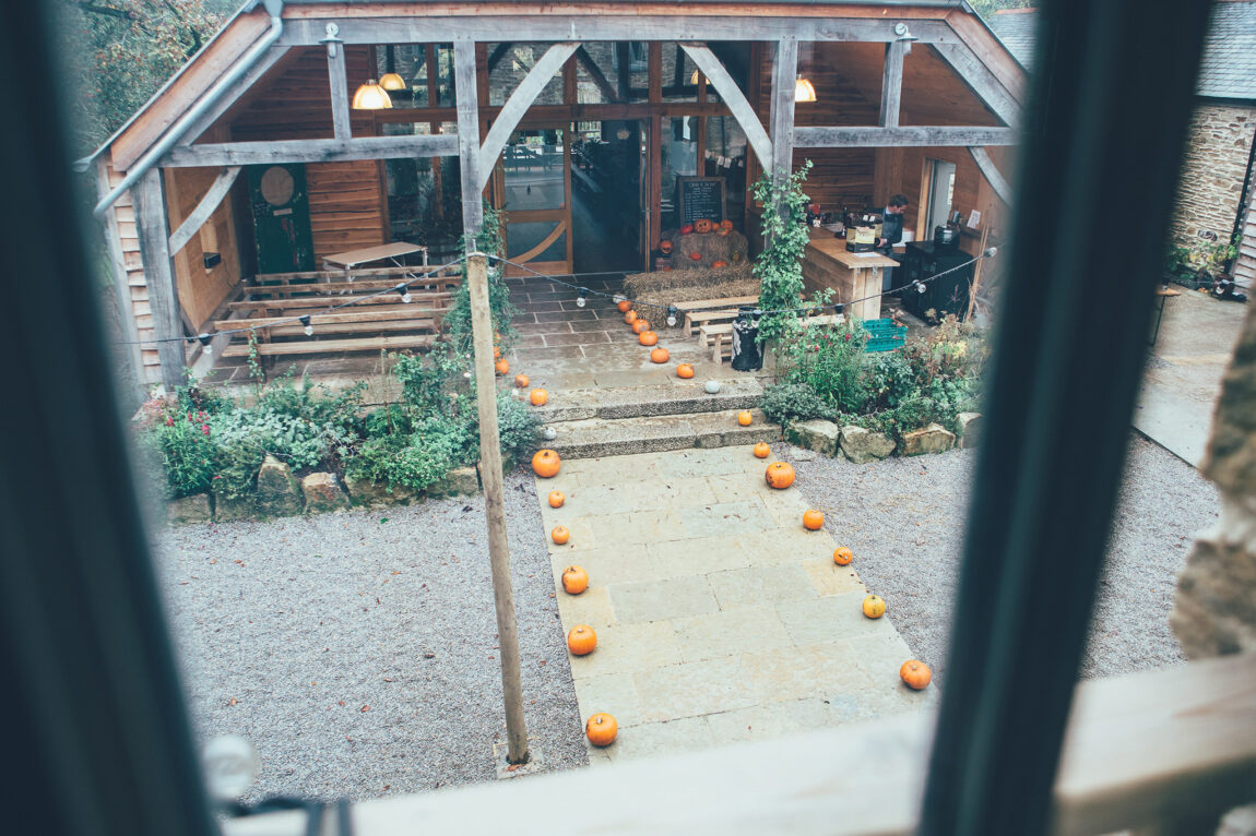 The barn at Nancarrow Farm seen through a window, set for the ceremony