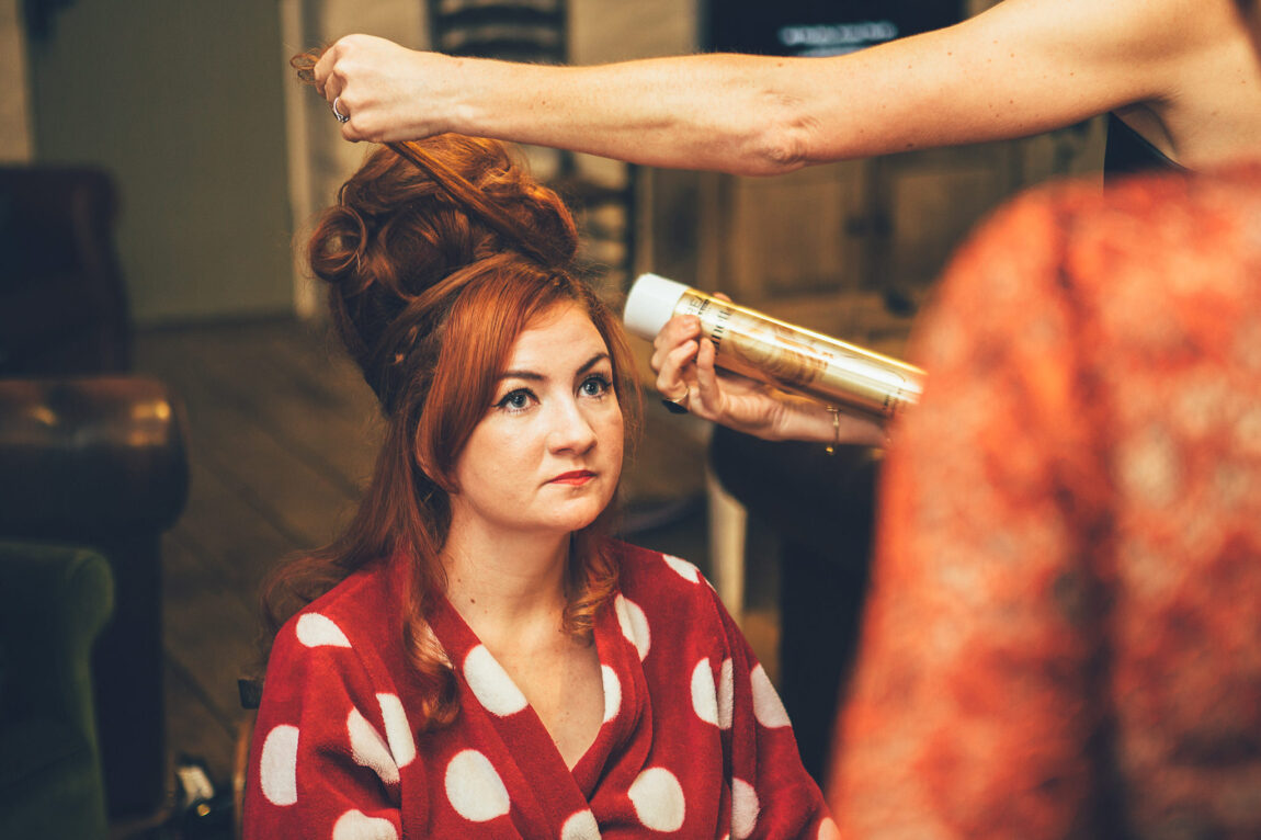 Bride getting ready in a red polka dot dress at Nancarrow Farm