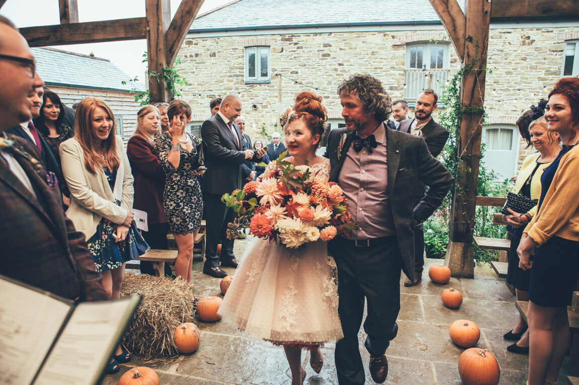 Bride walking down the aisle through guests at Nancarrow Farm