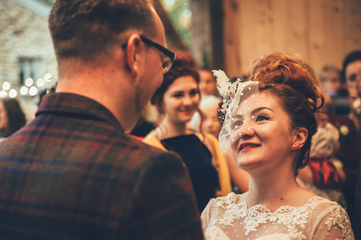 Bride smiling at the groom during the ceremony at Nancarrow Farm