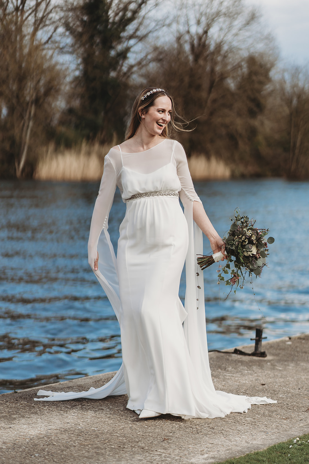 Bride laughing beside the Thames at Oakley Court