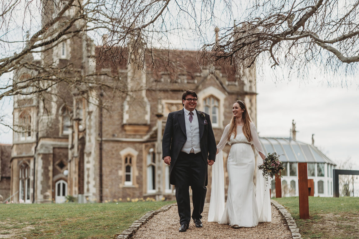 Bride and groom walking in front of Oakley Court