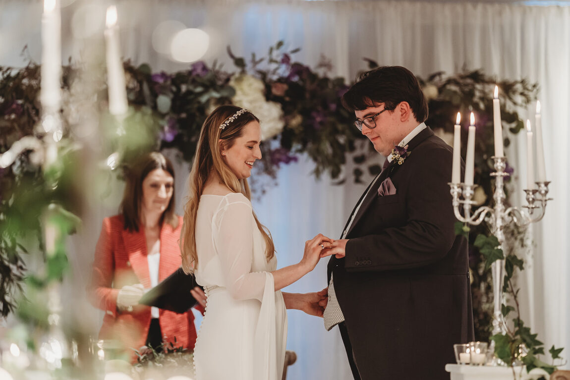Exchanging rings during an Oakley Court wedding ceremony
