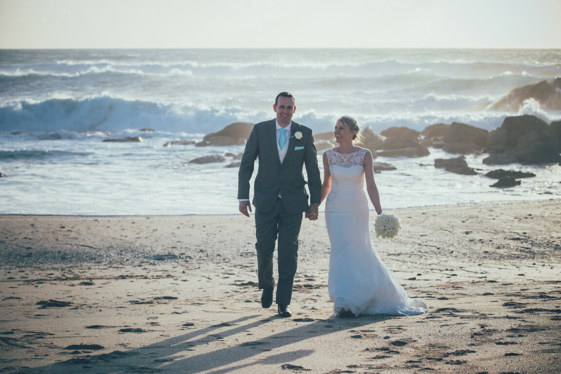 Couple walking on the beach on their wedding day