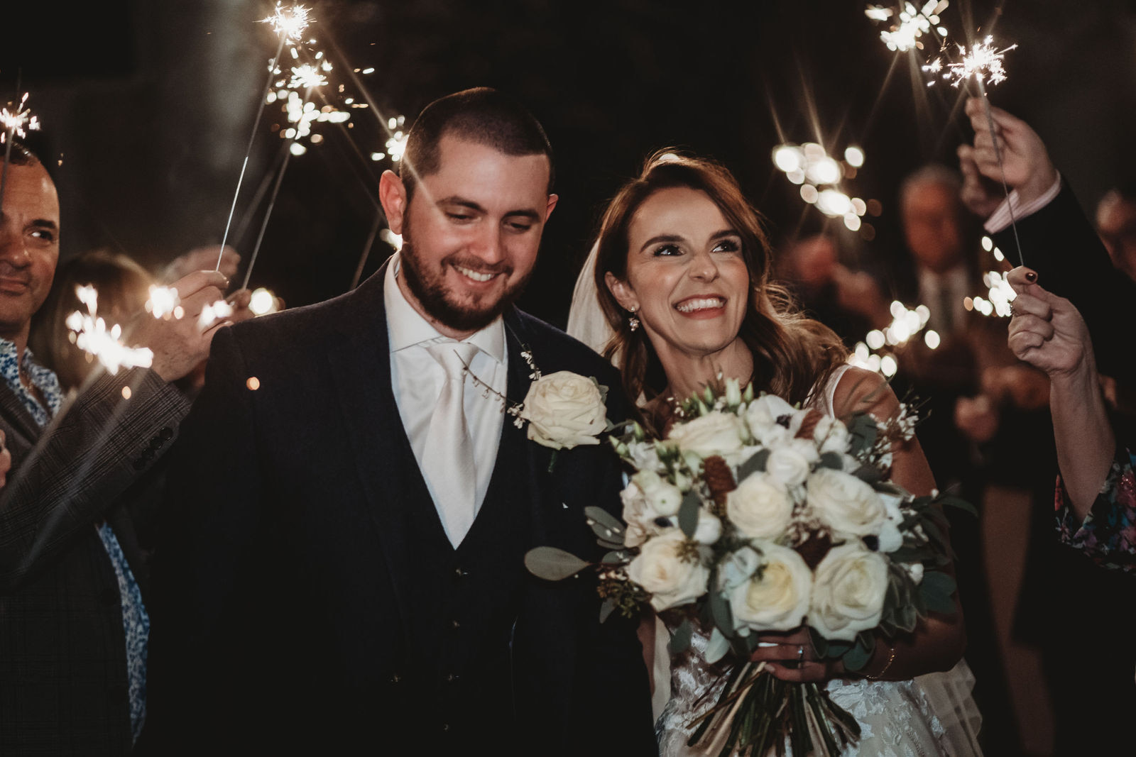 Bride and groom laughing through a sparkler send-off at Sopwell House, St Albans, by Sopwell House wedding photographer Matt Wing
