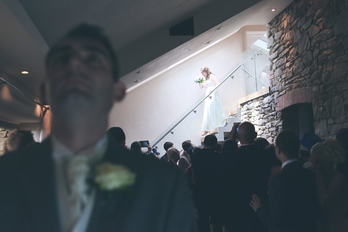 Bride coming down the stairs to her ceremony at Trevenna, Cornwall