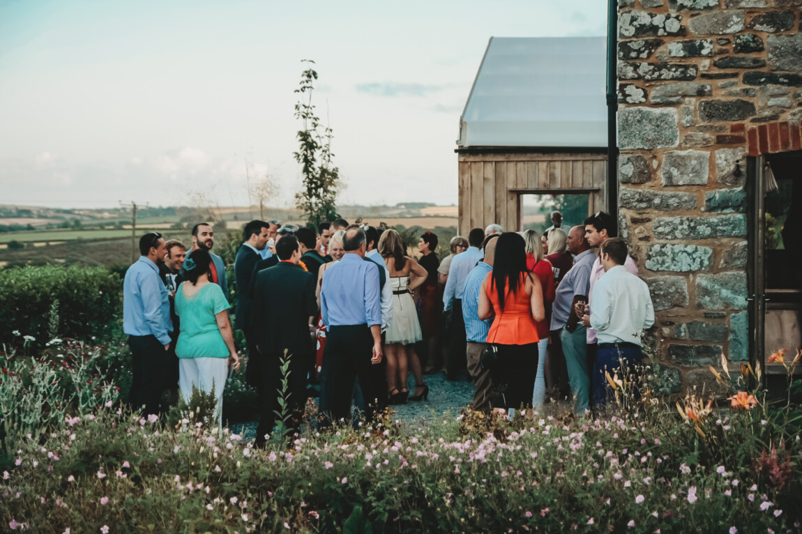 Guests gathered by the stone barns at Trevenna with views across the Cornish countryside
